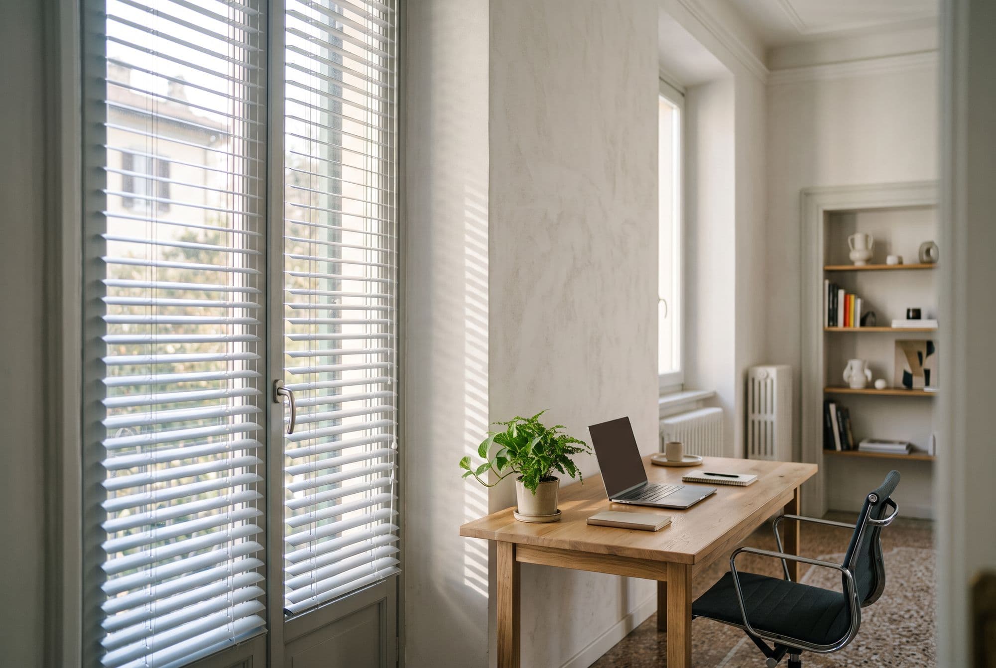 Ufficio in casa con veneziane in alluminio grigio chiaro e lamelle socchiuse